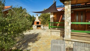 A stone pathway leading to a rustic building with a chimney, surrounded by olive trees and a clear blue sky. - Kalebica by Interhome (Pašman/Pašman)