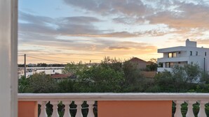 Ein Balkon mit Geländer, der auf einen Yachthafen mit Booten und Gebäuden blickt.