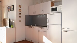 A modern kitchen with white cabinets, a built-in microwave, and a stainless steel sink. - Apartment Popara by Interhome (Crikvenica/Jadranovo)