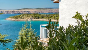 A balcony with a view of a turquoise sea, rocky coastline, and distant mountains. - Apartment Popara by Interhome (Crikvenica/Jadranovo)