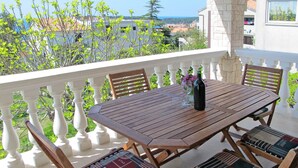 A wooden table with six chairs, a bottle, and a glass on the balcony. - Villa Ursa by Interhome (Pula)