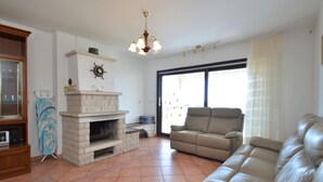 A living room with a fireplace, a sofa, and a television. - Villa Ursa by Interhome (Pula)