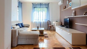 A compact living space with a sofa, a small table, a TV, and a cabinet.