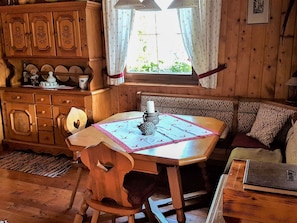 Cozy room with a traditional dining table, comfortable seating area, and a wooden cabinet.