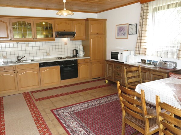 A compact kitchen with wooden cabinets, a microwave, and a coffee maker. - Lassnig by Interhome (Arriach)