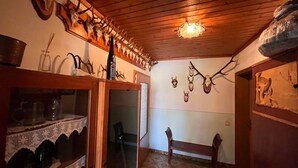 A room with wooden ceiling beams, a bench, and wall-mounted animal skulls. - Apartment Moser by Interhome (Stein an der Enns)