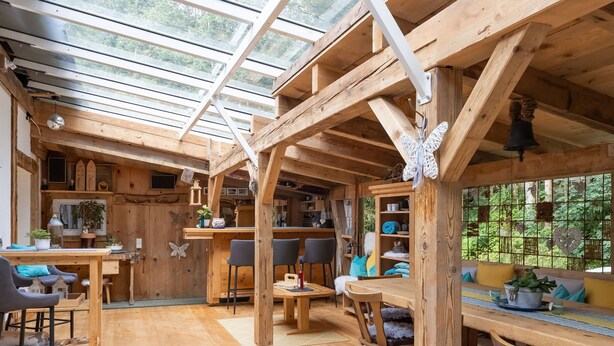 A wooden interior with a glass ceiling, wooden furniture, and a view of greenery outside. - Alpenchalet Silbertal by Interhome (Silbertal)