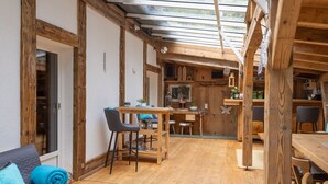 A cozy wooden interior with a dining area, kitchen, and seating space. - Alpenchalet Silbertal by Interhome (Silbertal)