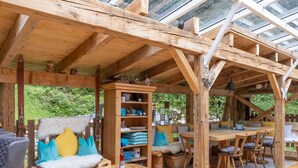 A wooden interior with a dining table, chairs, and a sofa with colorful cushions. - Alpenchalet Silbertal by Interhome (Silbertal)