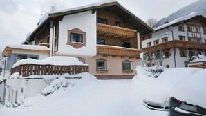 Un edificio de varios pisos con un balcón, rodeado de nieve.
