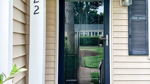 Une maison avec une porte noire, un revêtement de couleur beige et le numéro « 2322 » sur le poteau de la boîte aux lettres.