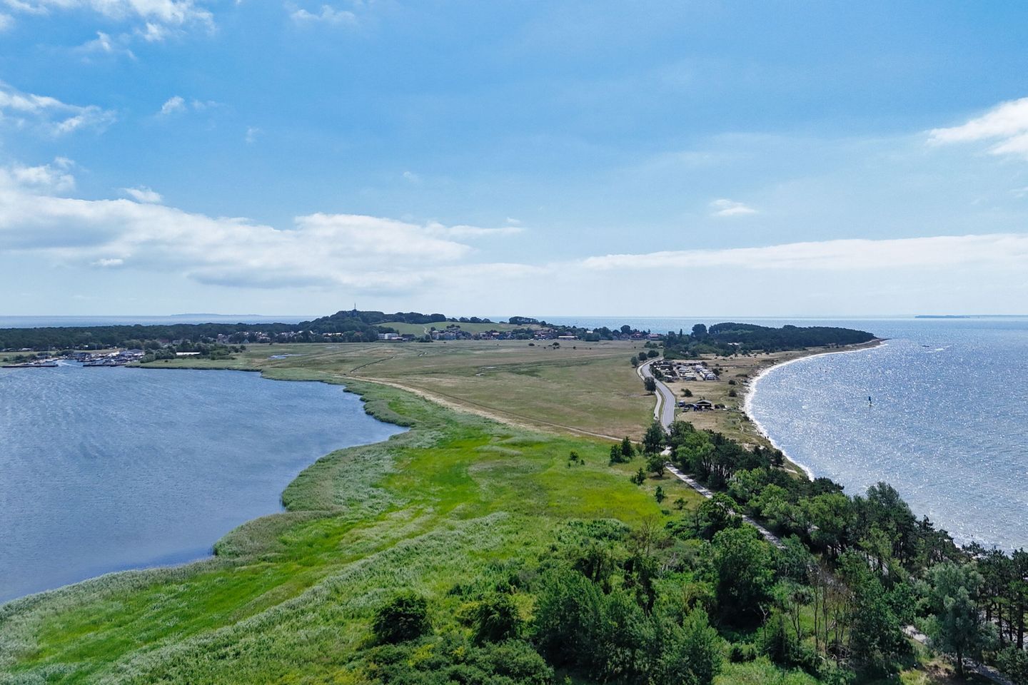 A coastal landscape with a river, a beach, and a small settlement.