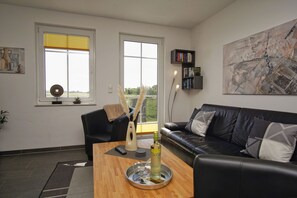 Ein modernes Wohnzimmer mit einer Ledersofa, einem Holztisch und einem Bücherregal.