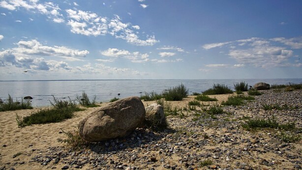 A beach with pebbles, sand, and rocks.