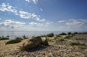 Una playa con piedras, arena y rocas.