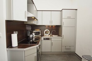 Eine kleine Küche mit Mikrowelle, Kaffeemaschine und Spüle.