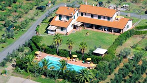 A large two-story house with a swimming pool, surrounded by lush greenery and a hilly landscape. - Le Macine by Interhome (Cecina)