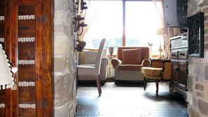 A stone-walled staircase leading to a living area with a wooden ceiling, a fireplace, and a view through a window. - Capo Corso by Interhome (Corsanico)