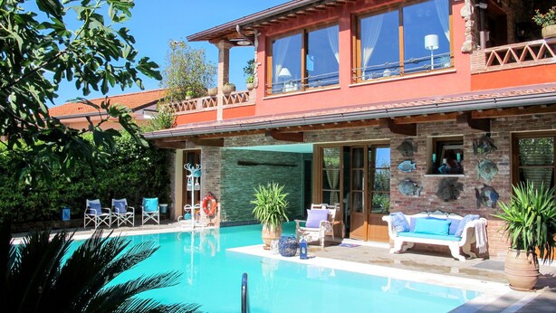 A two-story house with a swimming pool, outdoor seating, and a stone facade. - Capo Corso by Interhome (Corsanico)