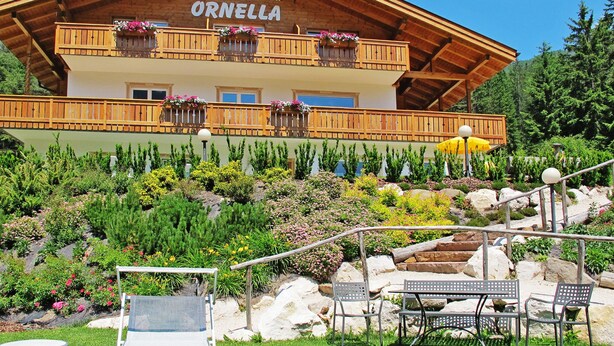 Een houten gebouw met balkons, aangeduid als 'Residence - Garni ORNELLA'.