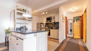 A modern kitchen with a central island, built-in appliances, and a dining area.