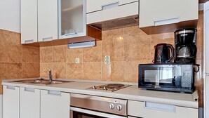 A modern kitchen with a built-in microwave, coffee maker, oven, and a sink. - Vacation home Gorana by Interhome (Brač/Splitska)