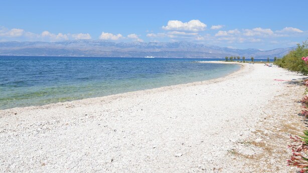 A beach with clear water, a pebble shore, and mountains in the background. - Vacation home Gorana by Interhome (Brač/Splitska)