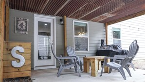 An outdoor patio with a wooden table and two chairs, a grill, and a 'BE ALERT' sign. - Pet-friendly home minutes from Downtown/UGA Campus (Athens)