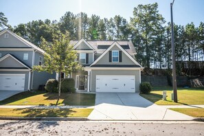 A two-story residential house with a garage, a front lawn, and a driveway. - Pet-friendly home minutes from Downtown/UGA Campus (Athens)
