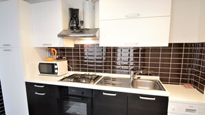 A modern kitchen with a microwave, toaster, stove, oven, and sink. - Apartment Josip by Interhome (Vodice)
