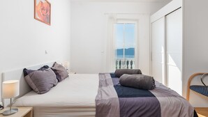 A bedroom with a bed, bedside tables, a window with a view, and a painting on the wall. - Albertina by Interhome (Mošćenička Draga)