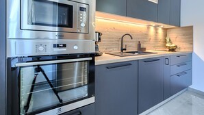 Een moderne keuken met roestvrijstalen apparatuur, een houten plank en een inbouwspoelbak.