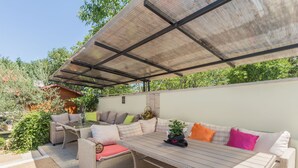 An outdoor seating area with wicker furniture, a covered table, and a 'VIP' sign on the wall. - Apartment Nena by Interhome (Poreč)
