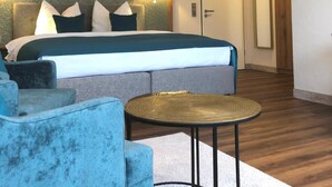 A hotel room with a bed, two wall-mounted lamps, a round table, and a door.