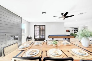 A dining area with a pool table, chairs, and a large potted plant. - LUX 7BA/4BA Oasis w/Heated Pool+Spa+Outdoor Living (Las Vegas)