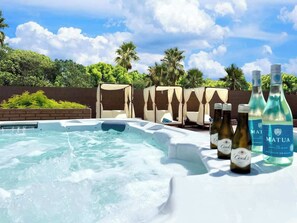 A hot tub with lounge chairs and bottles of Matua and Cook's wine. - LUX 7BA/4BA Oasis w/Heated Pool+Spa+Outdoor Living (Las Vegas)