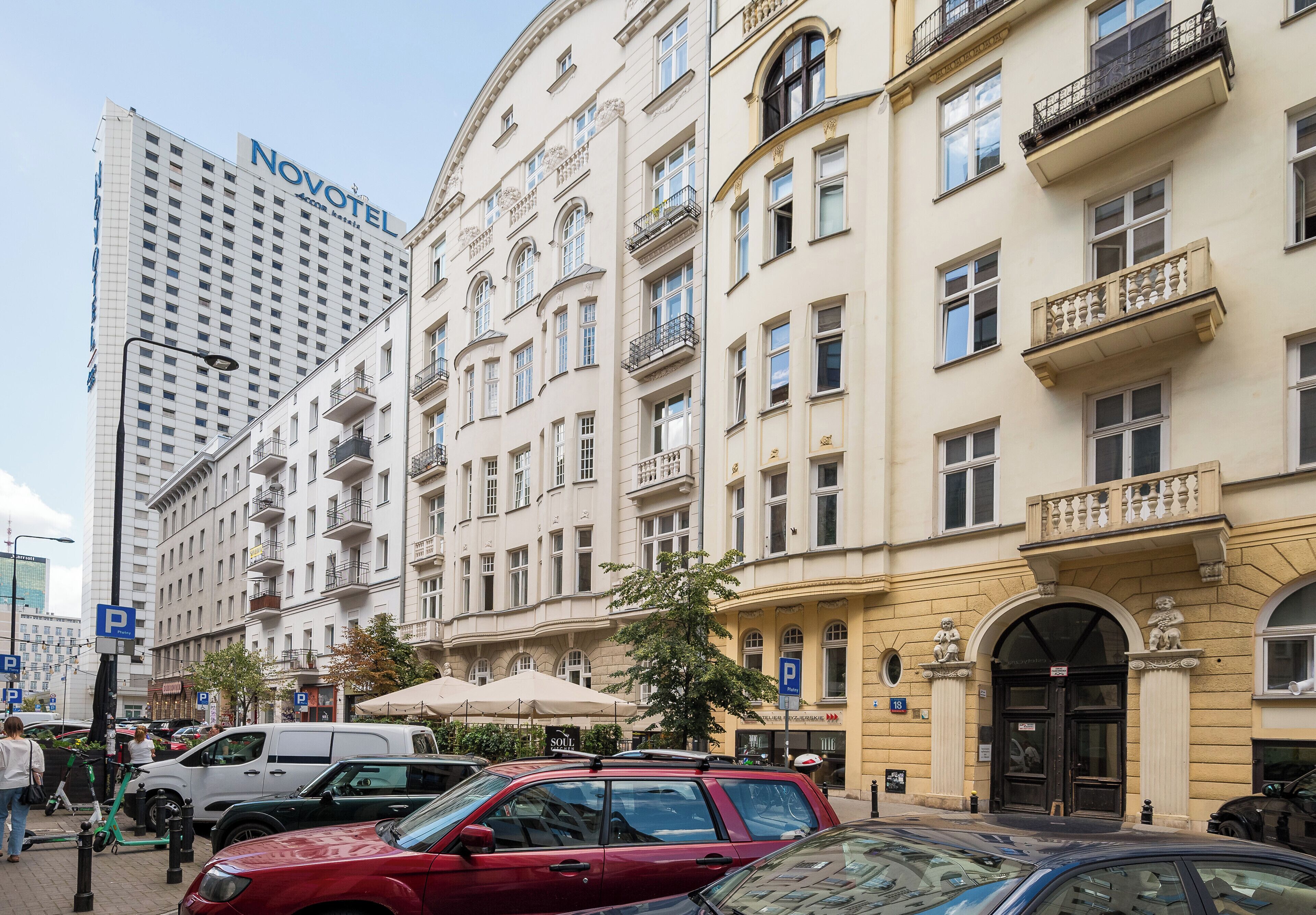 A hotel with a classic European architectural style, featuring multiple balconies and a prominent entrance.