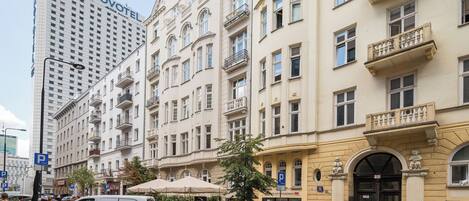 A hotel with a classic European architectural style, featuring multiple balconies and a prominent entrance.