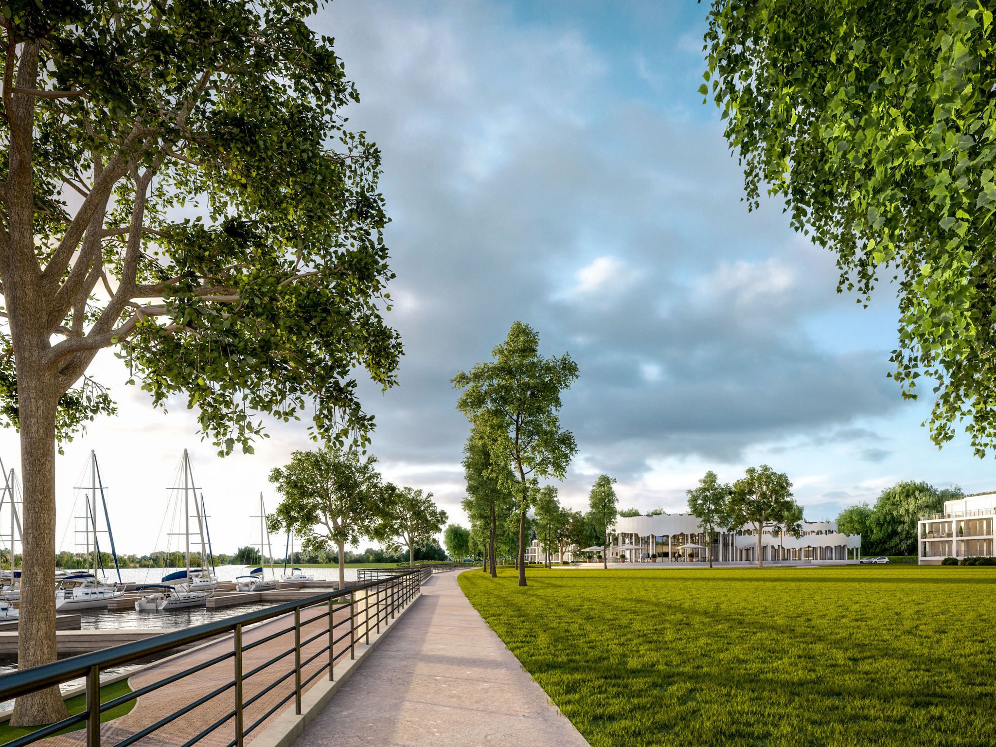 Eine Uferpromenade mit gepflastertem Gehweg, Bäumen und einem Hafen mit Segelbooten.