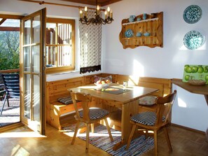 Enjoy meals in this inviting dining area with a wooden table, chairs, and a chandelier.