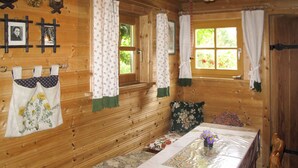 A wooden cabin interior with a dining table, chairs, and a bench. - Kunzhof by Interhome (Treffen)