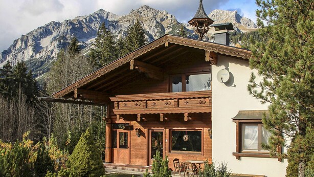 A wooden chalet with a balcony, large windows, and a mountain backdrop. - Walcher by Interhome (Ramsau am Dachstein)