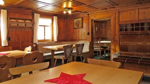Un coin repas en bois avec un set de table en forme d’étoile posé sur une table, entouré de chaises ornées de motifs floraux.