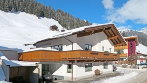 A modern chalet with a sloped roof, wooden balconies, and a ski lift in the background. - Haus Alina by Interhome (Tux)
