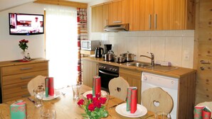 A modern kitchen with wooden cabinets, a microwave, stove, and dishwasher. - Klammlhof by Interhome (Zell am Ziller)