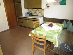 Cozy living space with a kitchenette, dining table, and comfortable sofa.