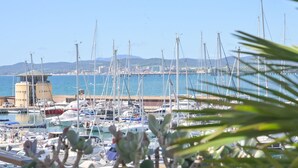 A marina with multiple boats docked, a control tower, and a clear view of the coastline in the background. - La Marina by Interhome (Scarlino)