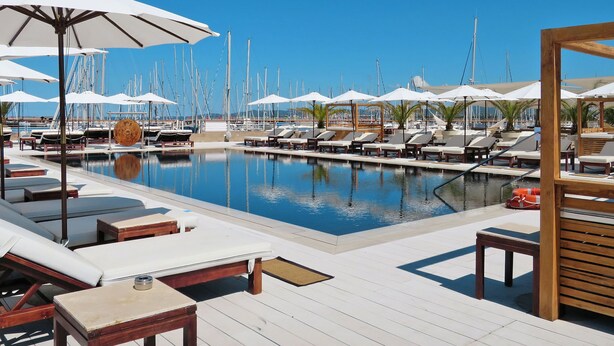 A marina with a swimming pool, lounge chairs, and umbrellas. - La Marina by Interhome (Scarlino)