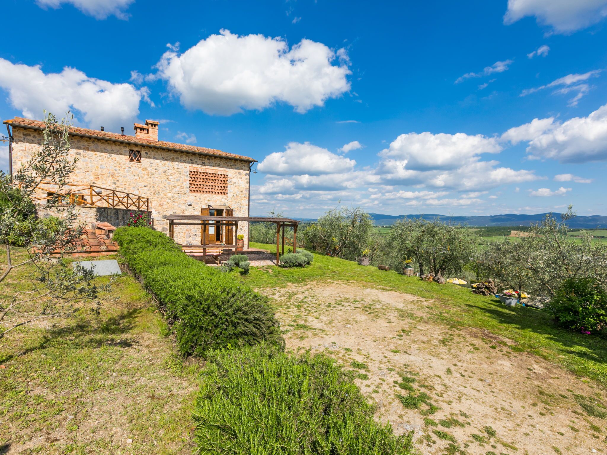 A stone house with a wooden porch and a view of the countryside.