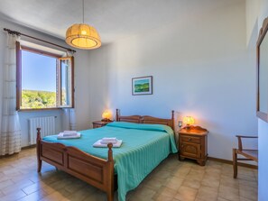 Enjoy a peaceful retreat with a large window offering a view of the surrounding green landscape.
